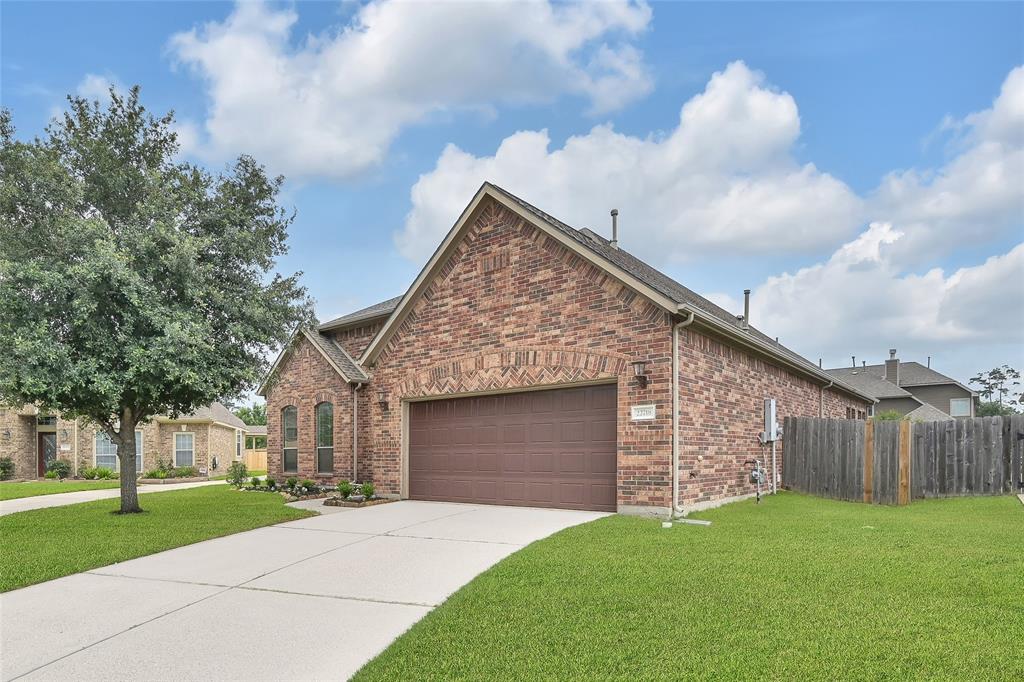 a brick house with a small yard and wooden fence