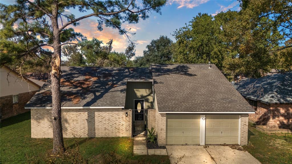 Charming single-story brick home with a two-car garage, surrounded by mature trees. Enjoy a well-kept lawn and inviting entrance, offering privacy and curb appeal in a peaceful neighborhood.