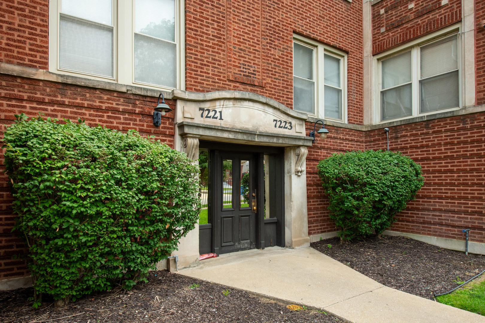 a view of a brick building with potted plants