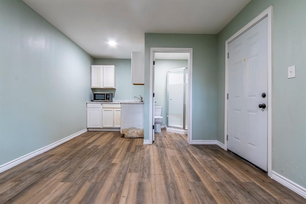 a view of a kitchen with a sink and dishwasher with wooden floor