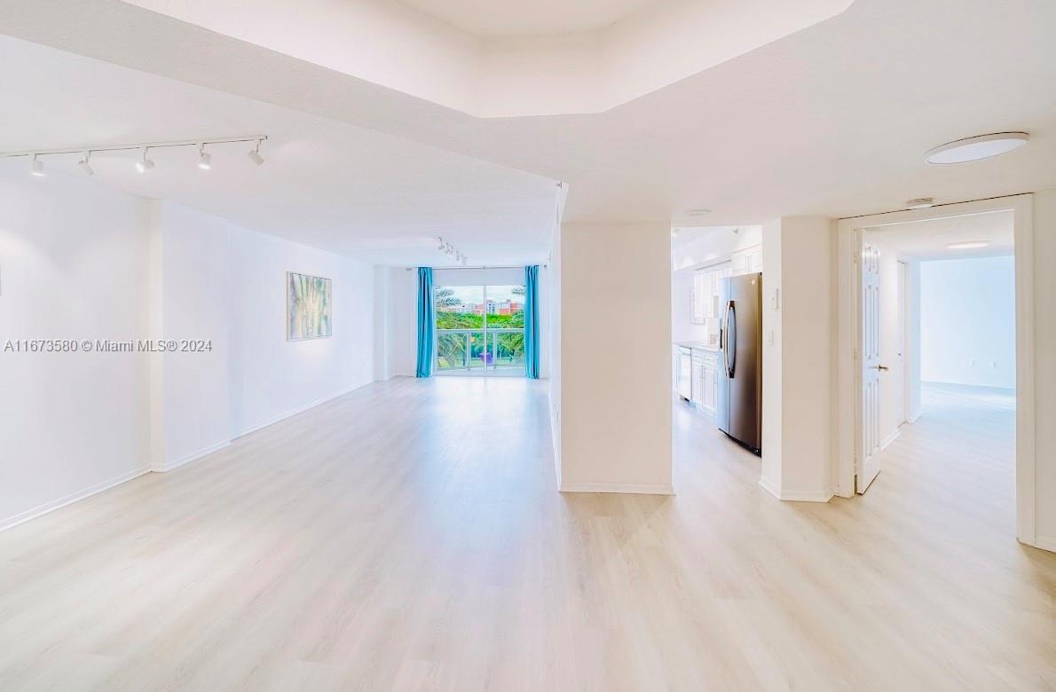 a view of a hallway with wooden floor and a bathroom