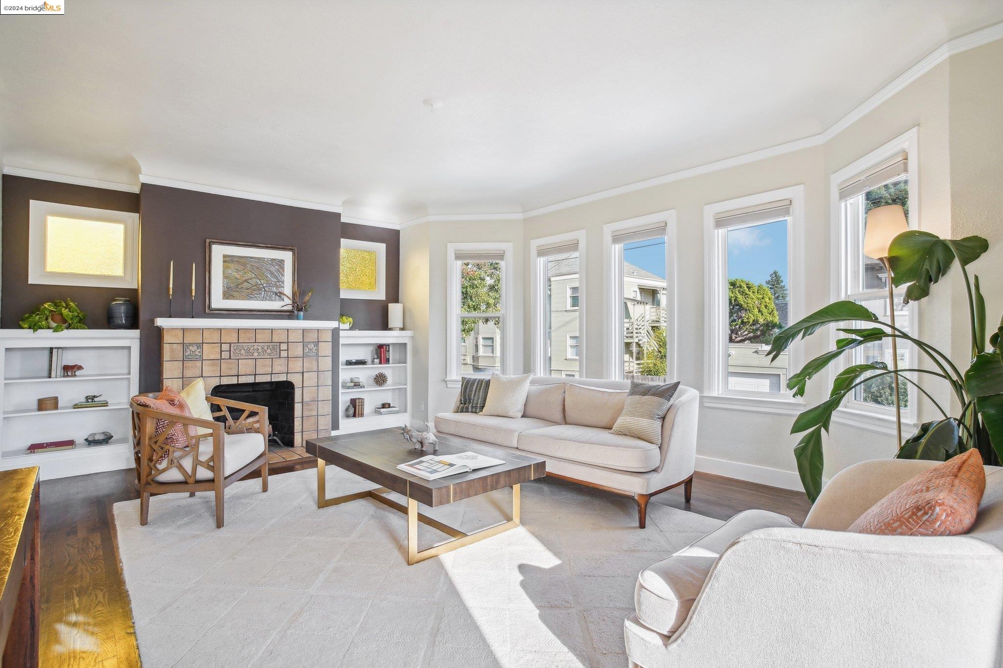 a living room with furniture a fireplace and a large window