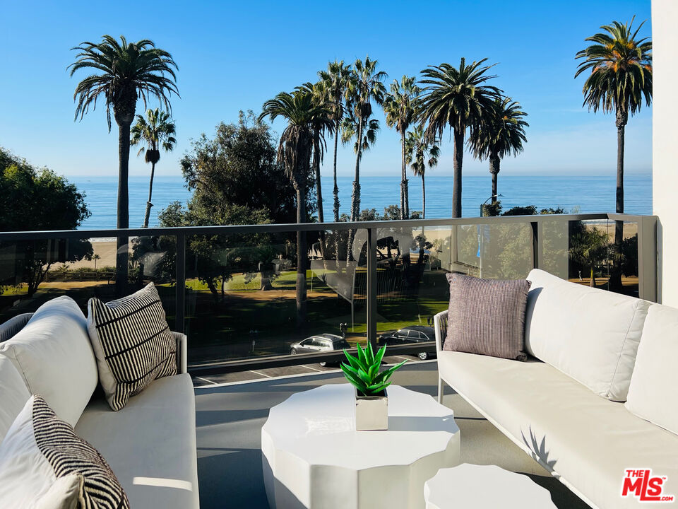 a roof deck with couches and potted plants with sky view