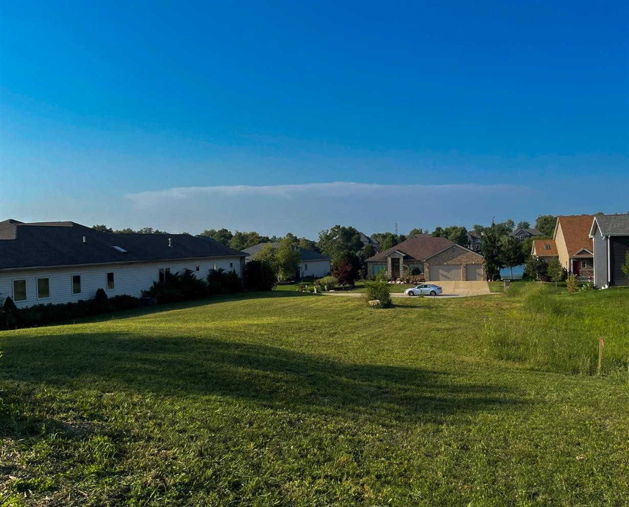 a big yard with lots of trees in the background