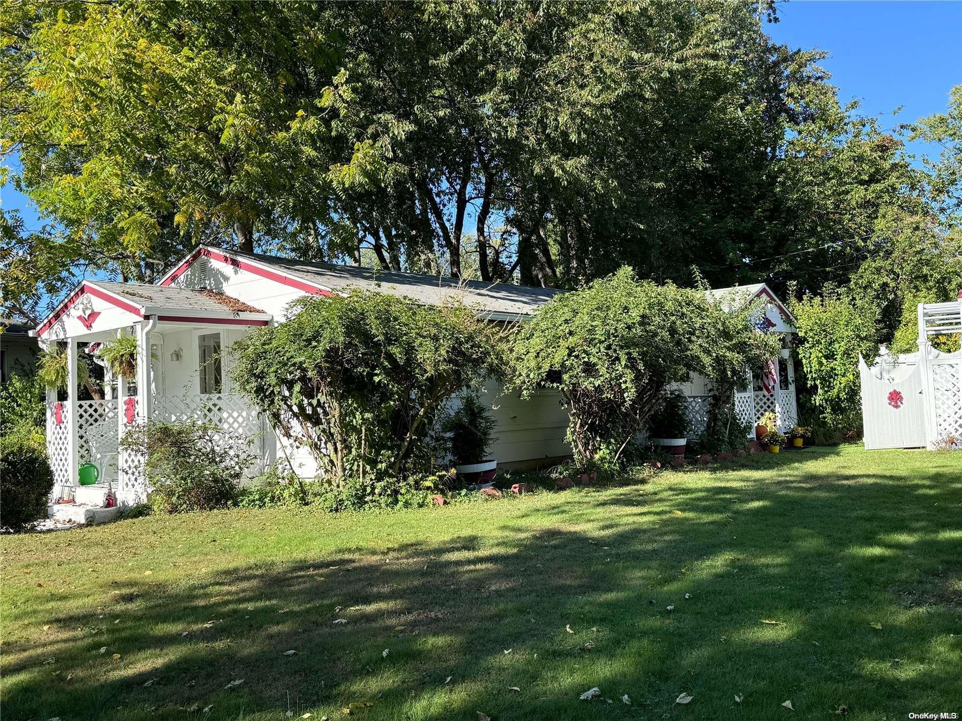 a backyard of a house with large trees and plants