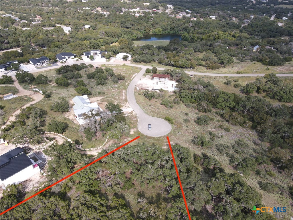 a aerial view of a house with a yard and lake view