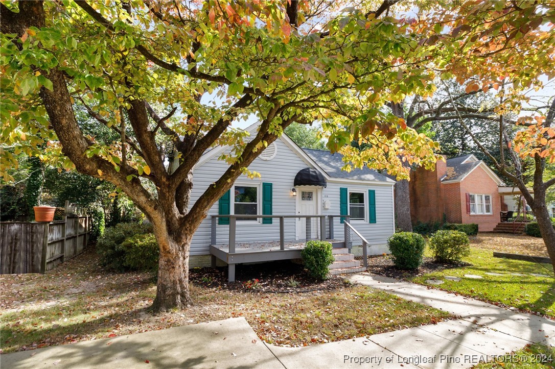 a view of a yard in front of a house with large tree