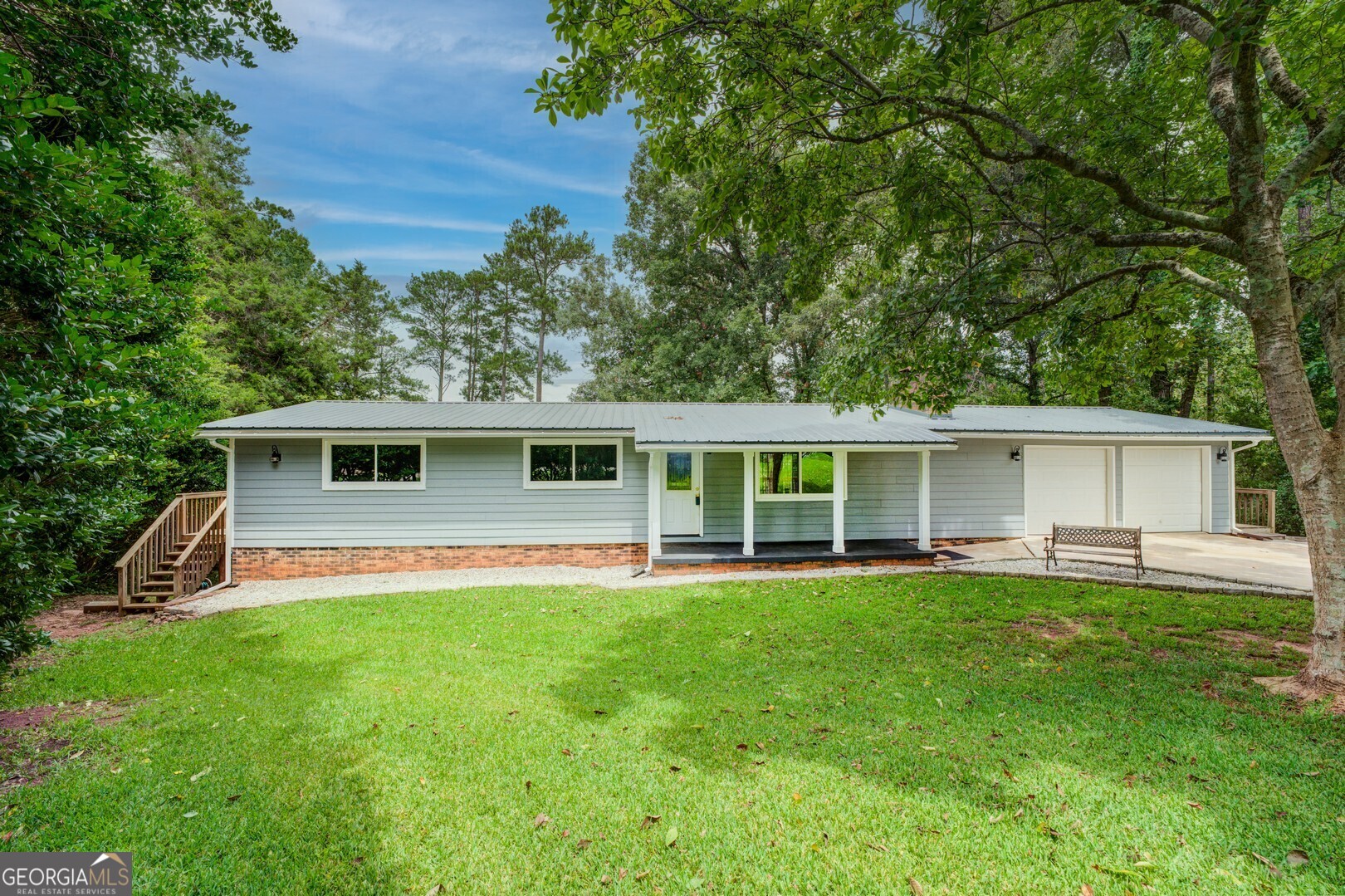 a front view of a house with a yard and trees