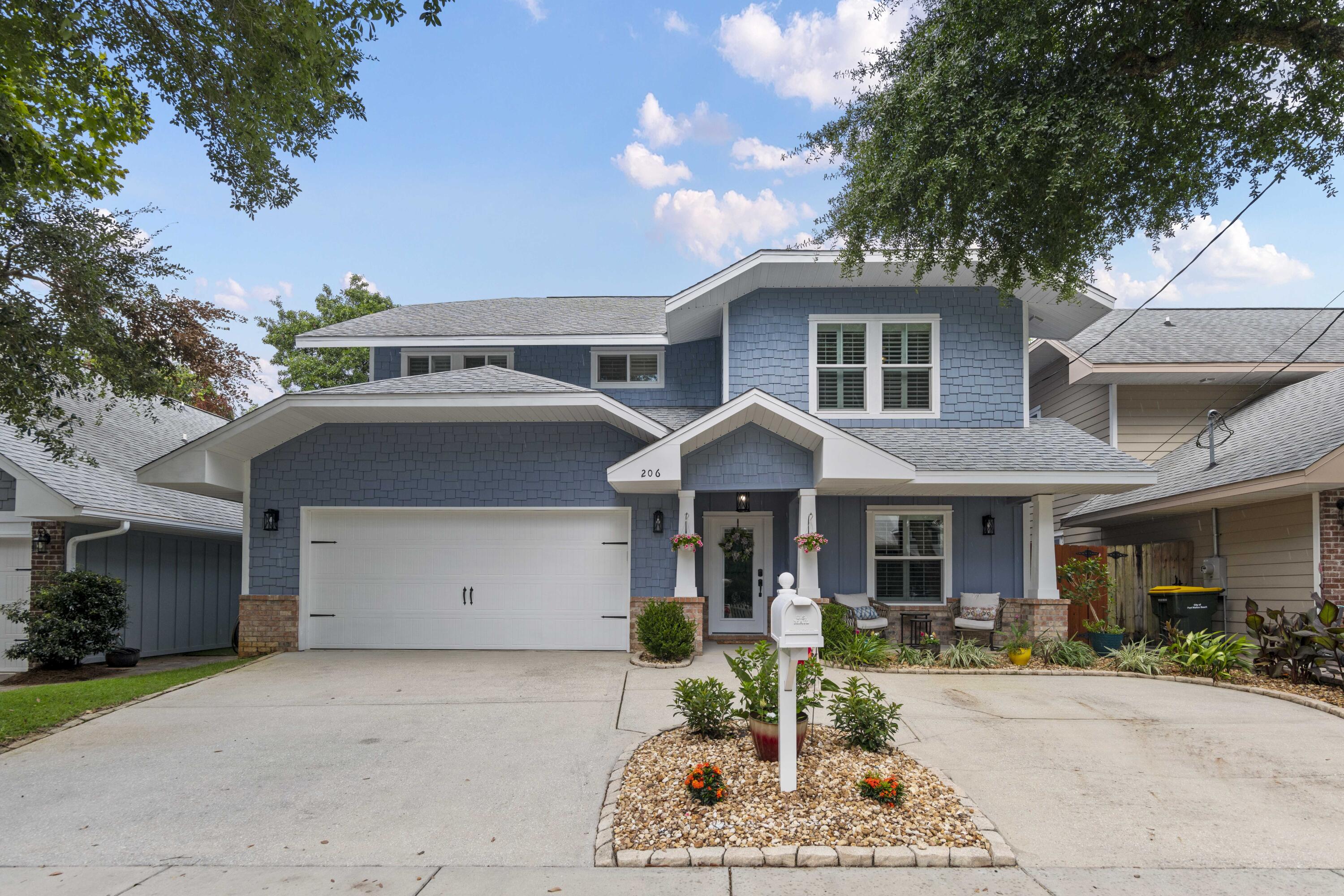 a front view of a house with plants and garage