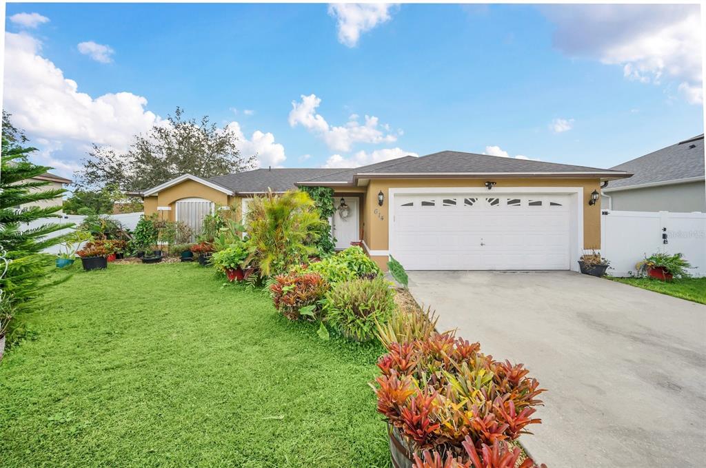 a front view of a house with a yard and a garage