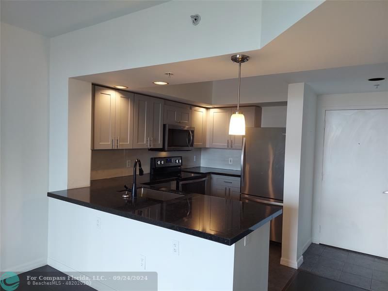 a kitchen with stainless steel appliances a sink and a refrigerator