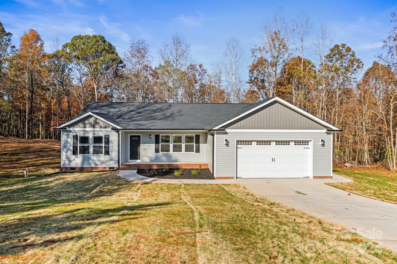 a front view of a house with a yard and trees