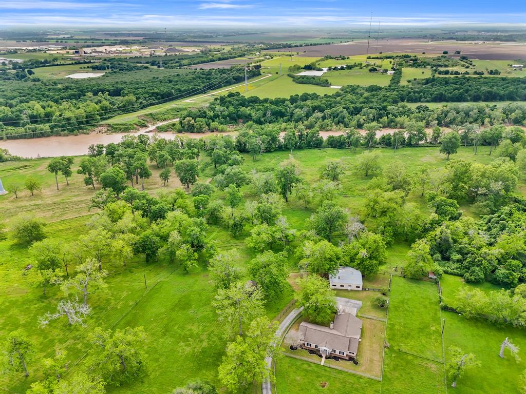 a view of a lush green field with lots of buildings in the background