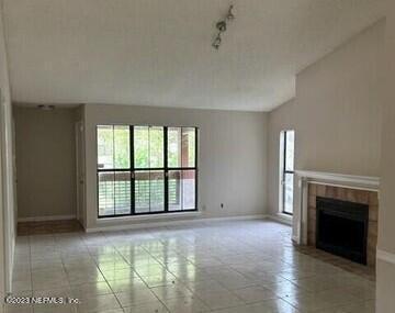 wooden floor fireplace and windows in an empty room