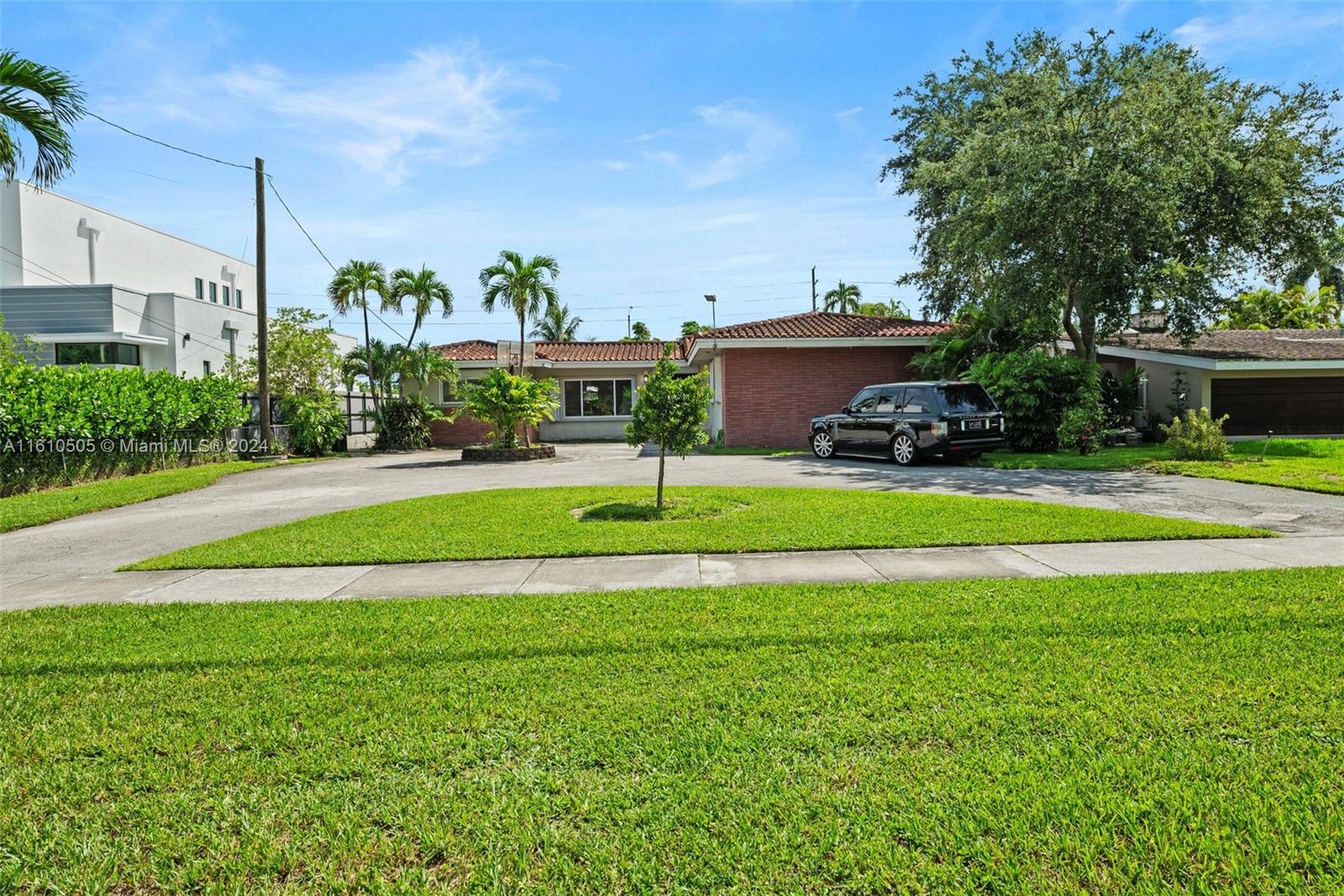 a view of a house with a big yard and potted plants