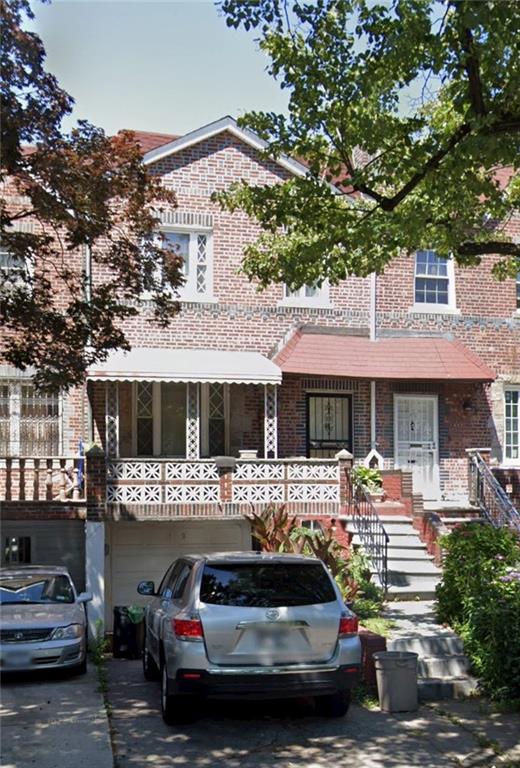 a front view of a building with cars parked