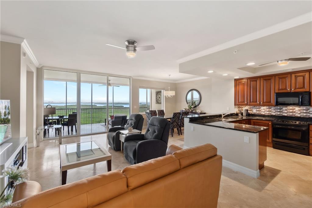 a living room with furniture kitchen view and large windows