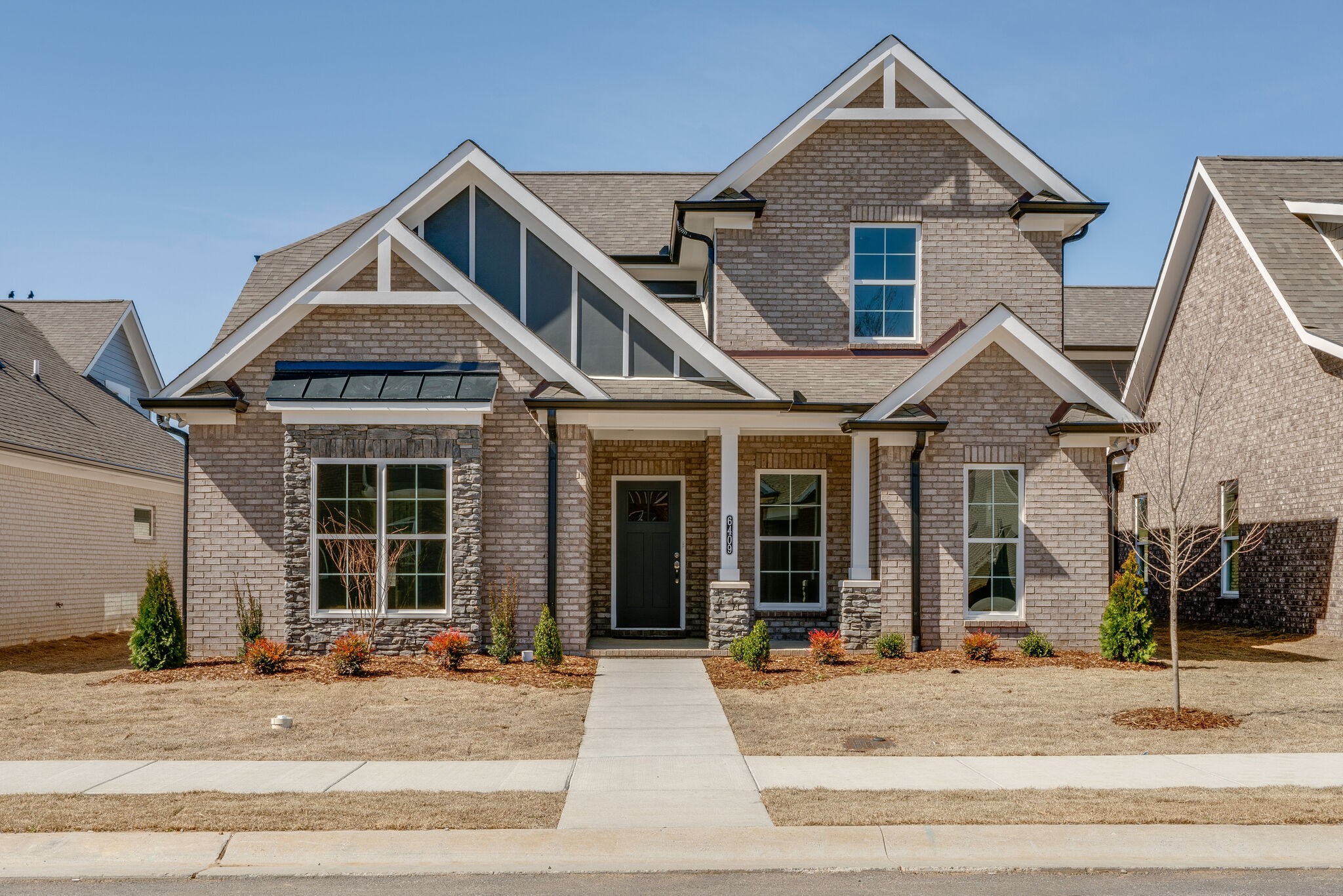 a front view of a house with garage and glass door