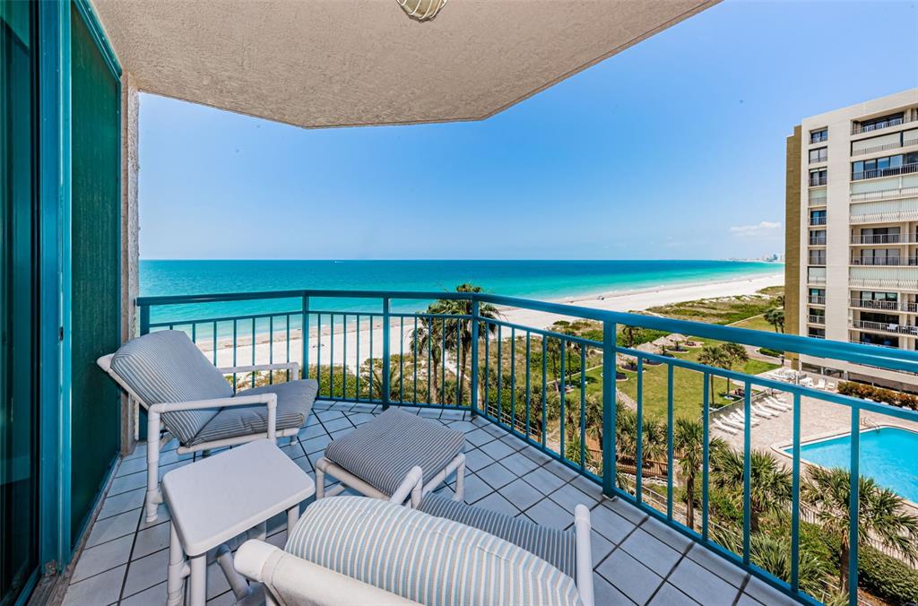 a balcony with chairs and wooden floor