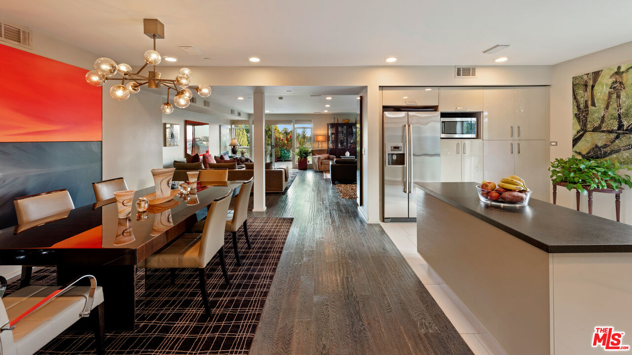 a view of a dining room and livingroom with furniture wooden floor a chandelier