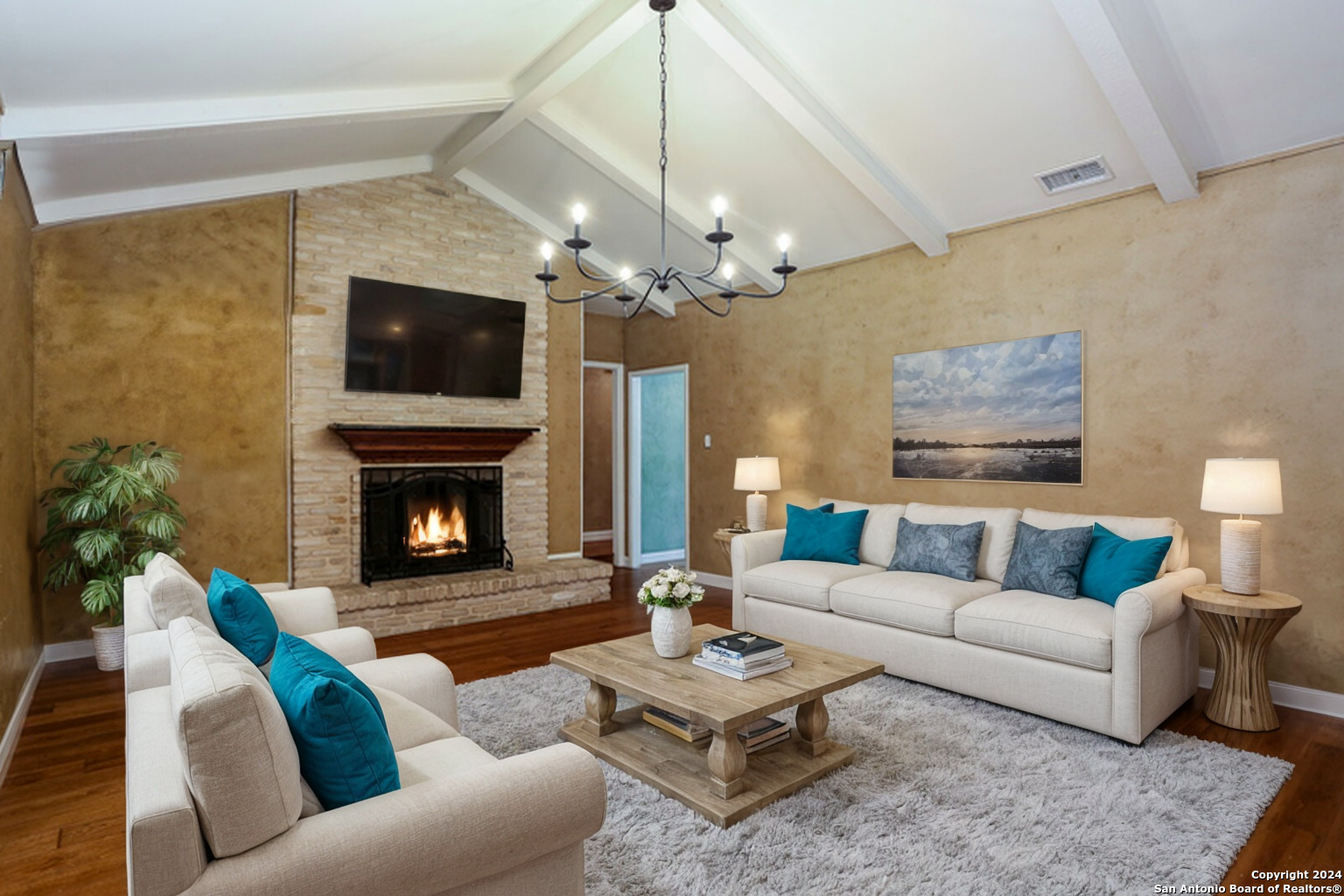 a living room with furniture a flat screen tv and a fireplace