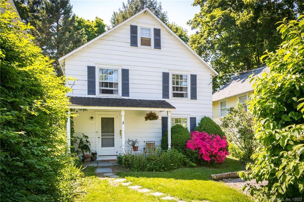 a front view of a house with a yard and fountain