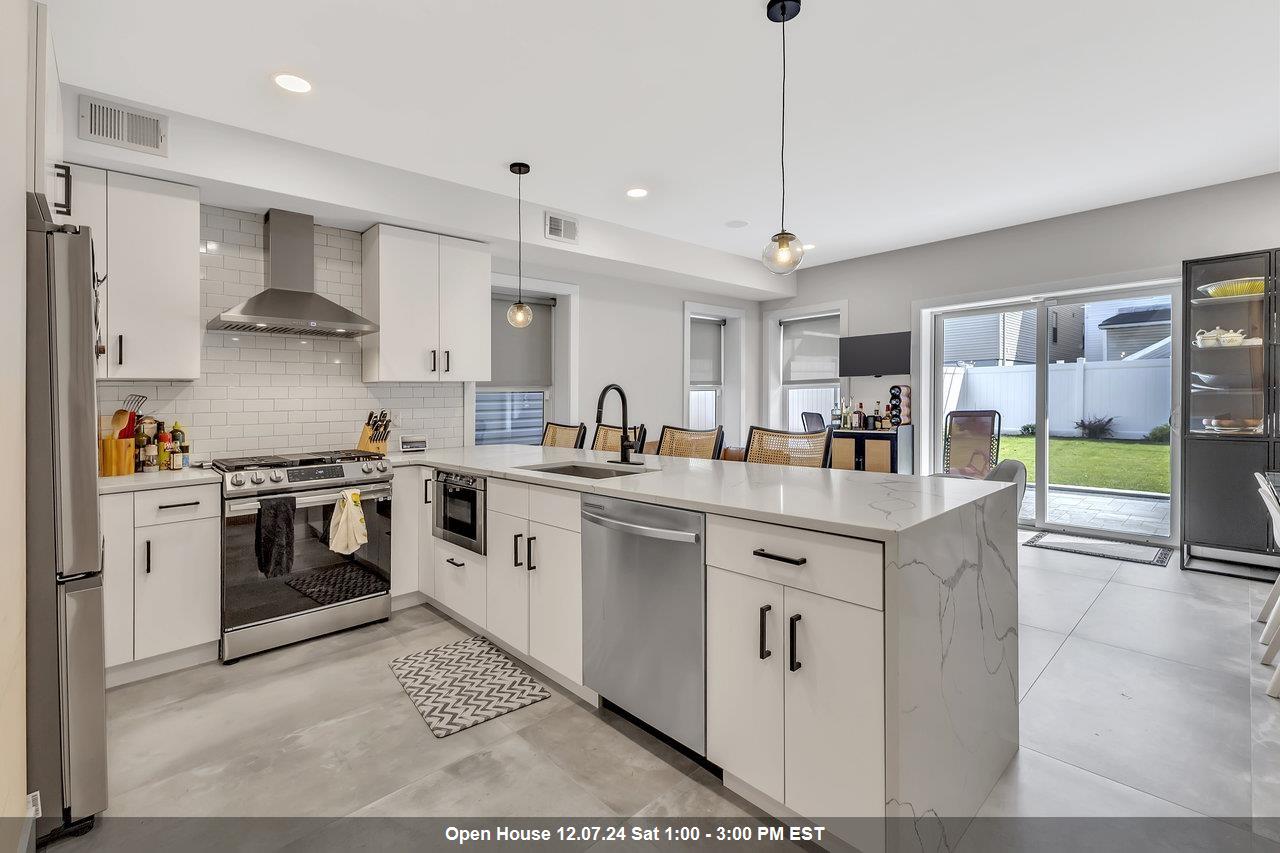 a kitchen with stainless steel appliances granite countertop a stove a sink and a refrigerator