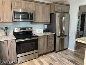 a kitchen with stainless steel appliances granite countertop a stove microwave and refrigerator