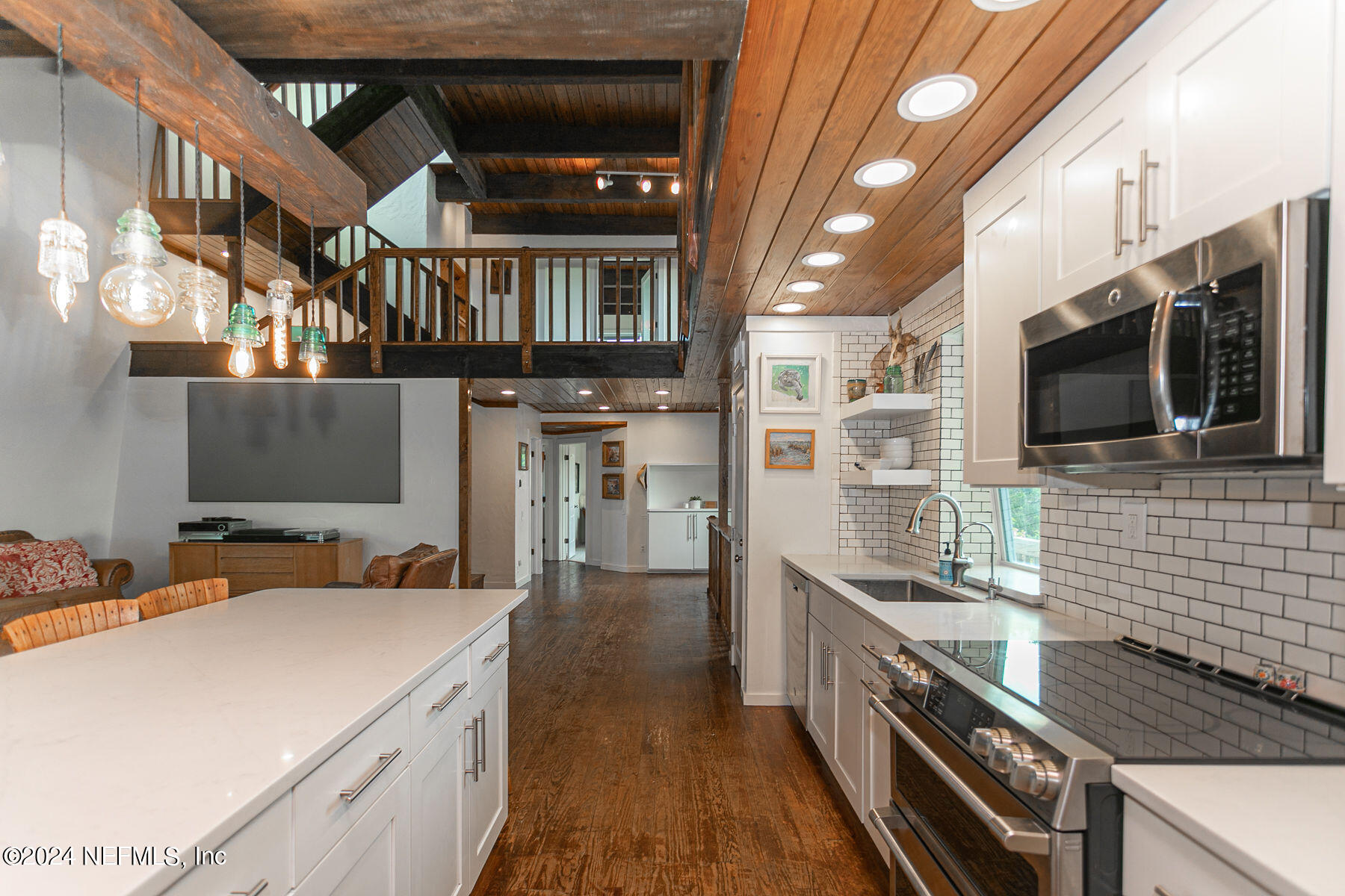 a kitchen with stainless steel appliances a stove a sink and a microwave