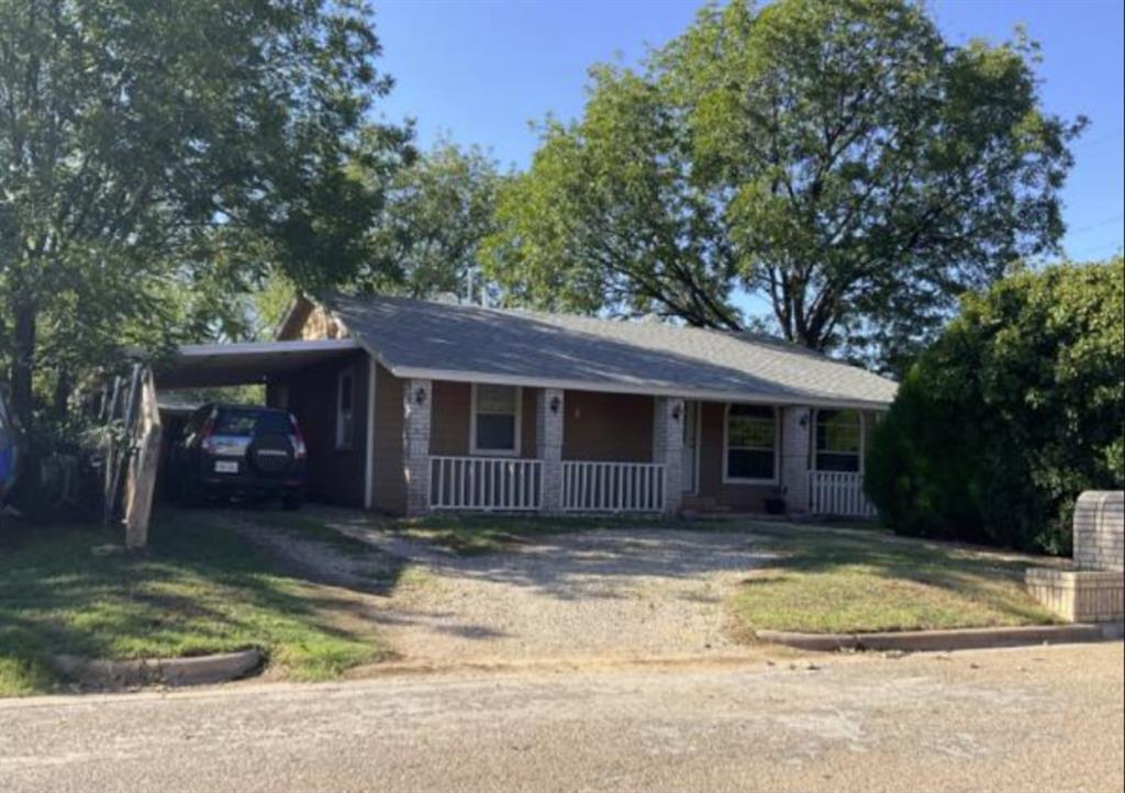 a view of a house with a yard and large tree