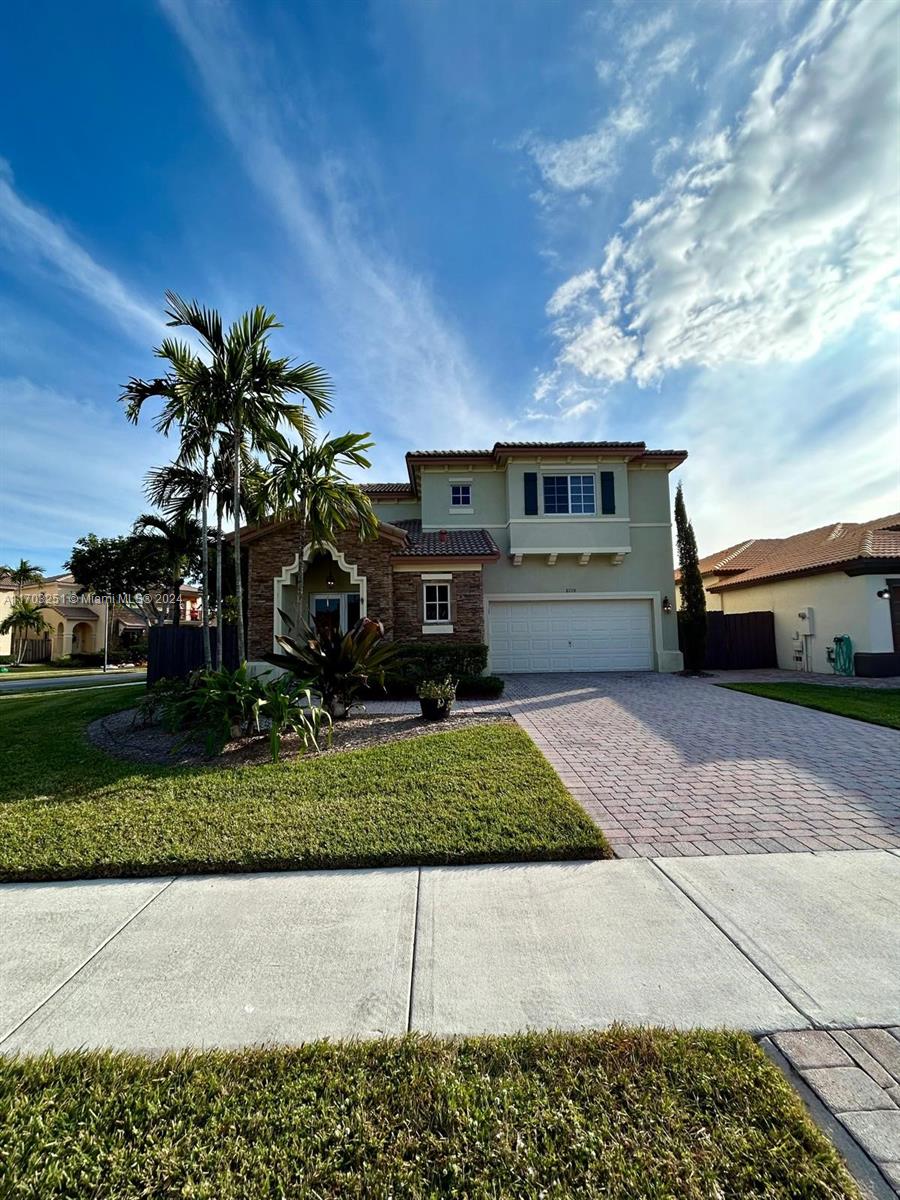 a front view of a house with a yard and garage