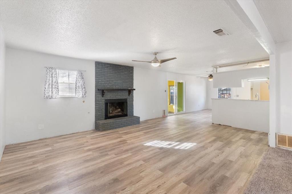 an empty room with windows and fireplace