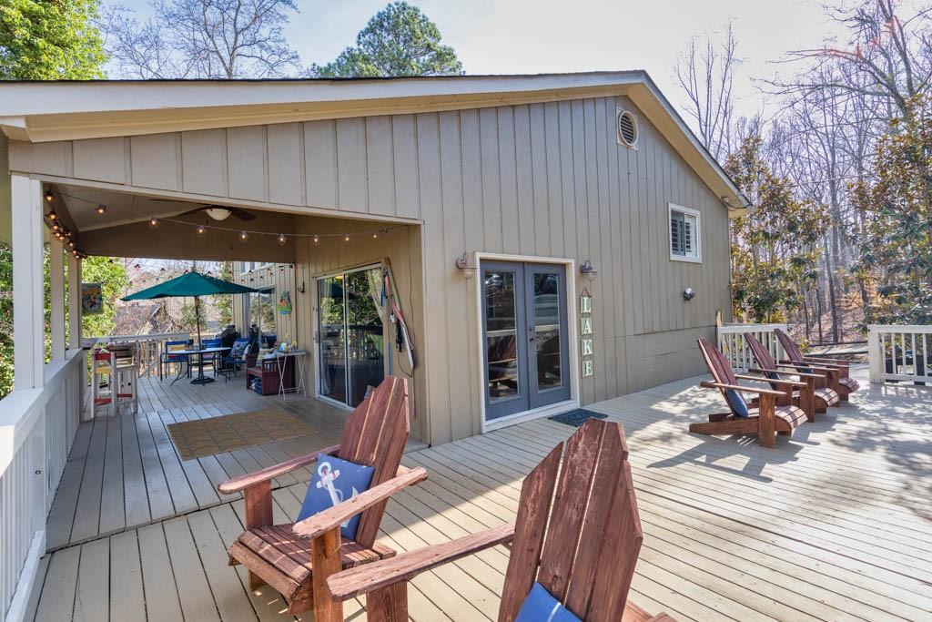 a view of a patio with table and chairs with wooden floor and fence