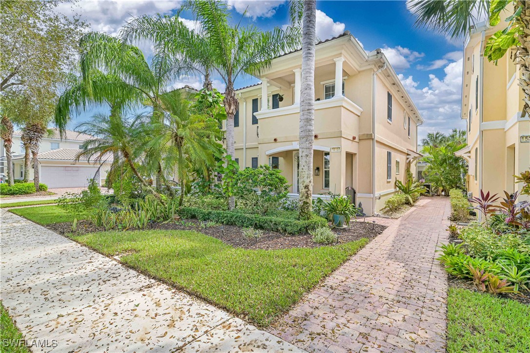 a view of a building with a yard with palm trees