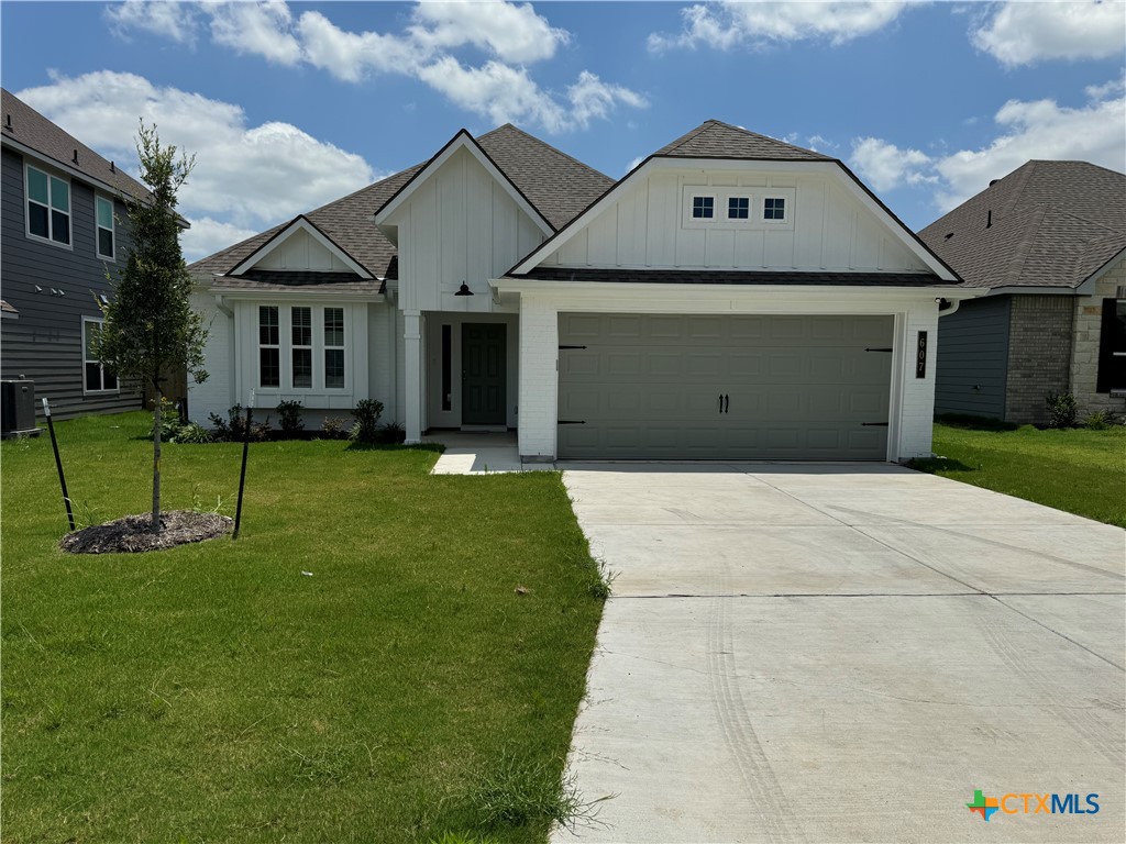 a front view of a house with a yard and a garage