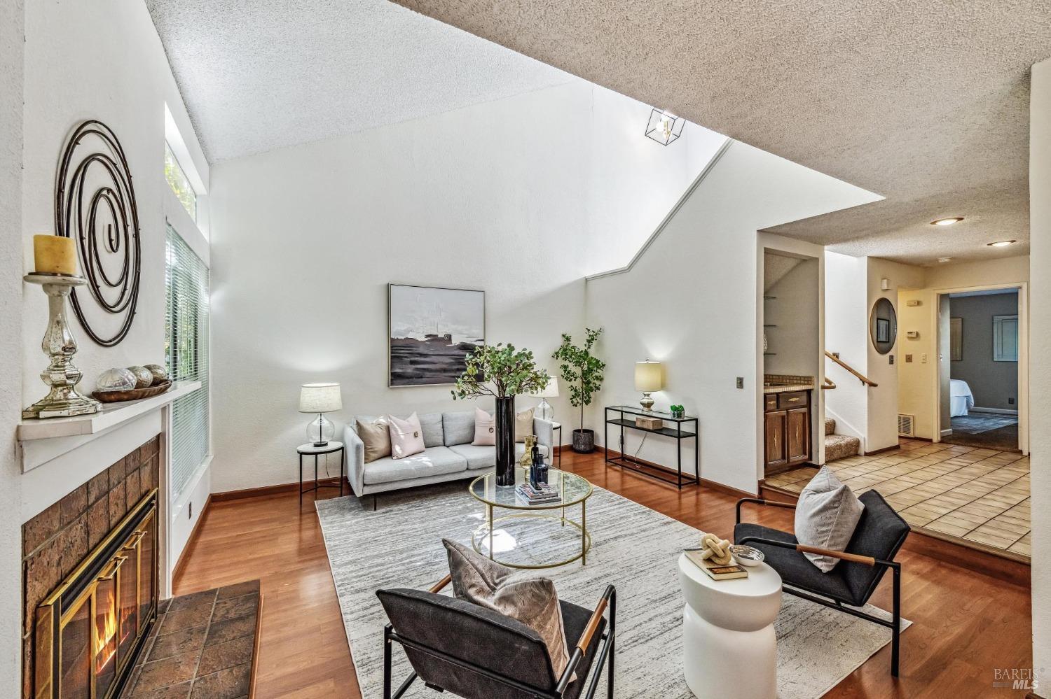 a living room with furniture a fireplace and kitchen view