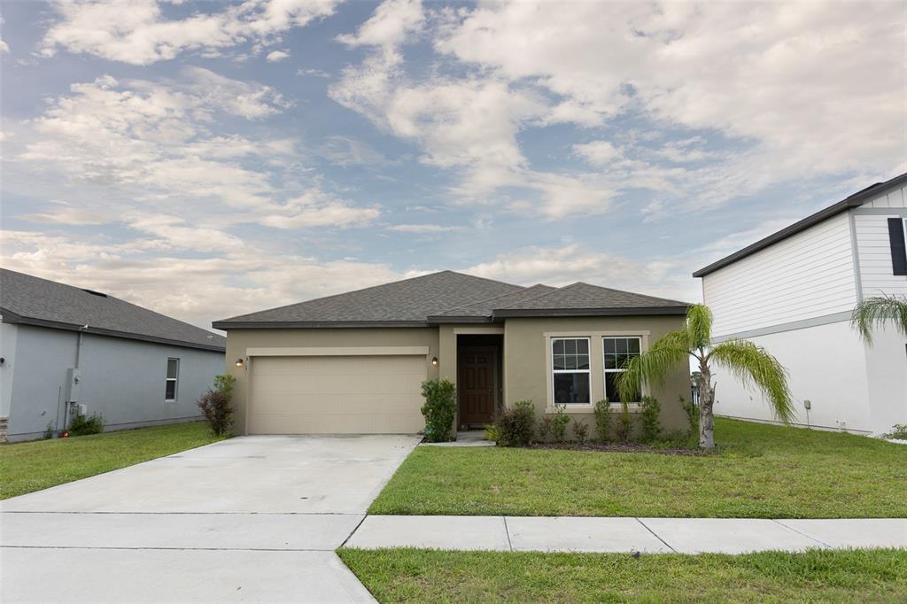 a front view of a house with a yard and garage