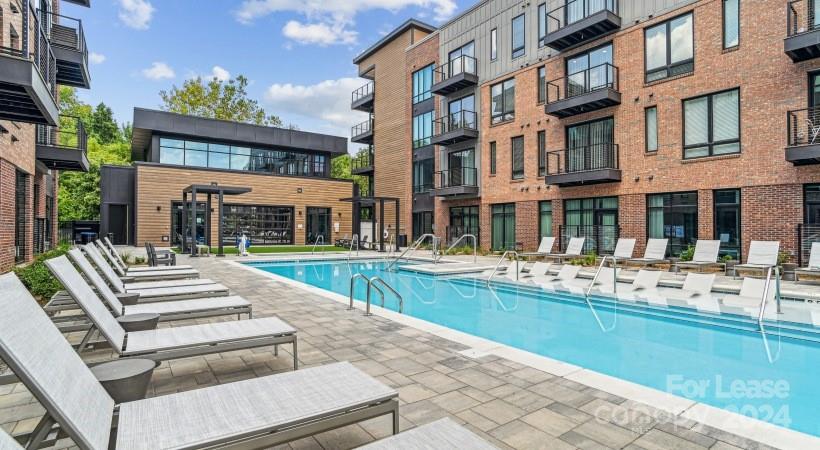 a view of a building with a swimming pool and a chairs and tables