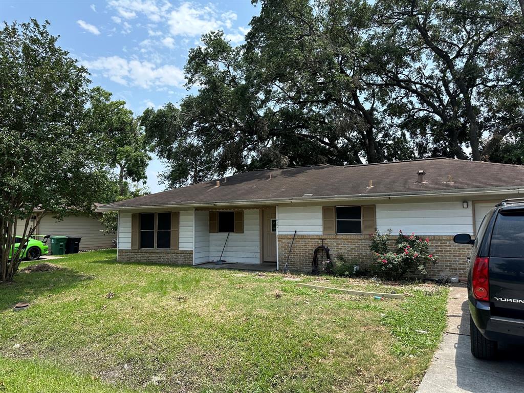 a front view of house with yard and trees around