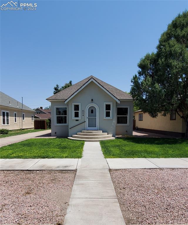 View of front of home with a front yard; sprinkler system (with drip system to the trees)