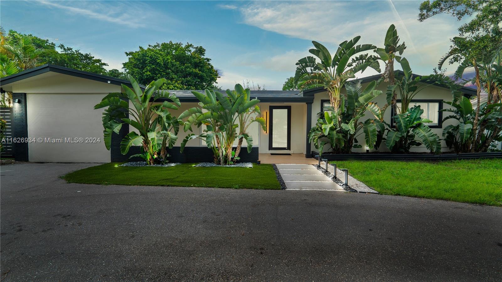 a view of a house with a yard and potted plants