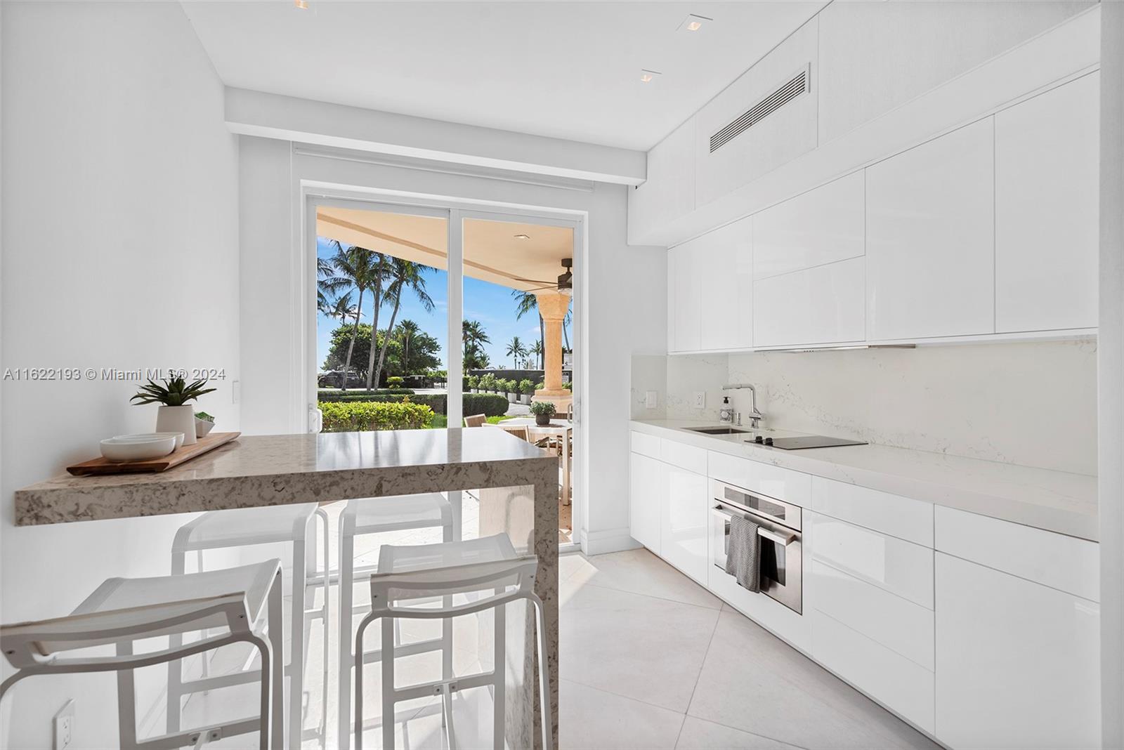 a kitchen with stainless steel appliances white cabinets and a large window