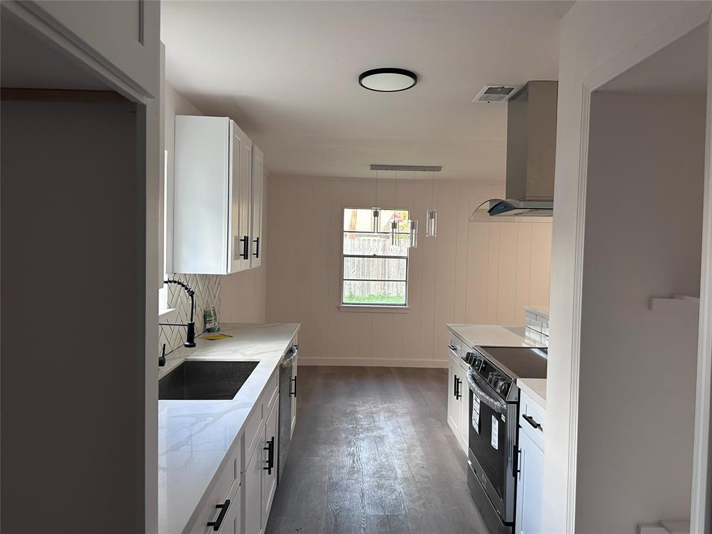 a kitchen with a sink a stove and a refrigerator