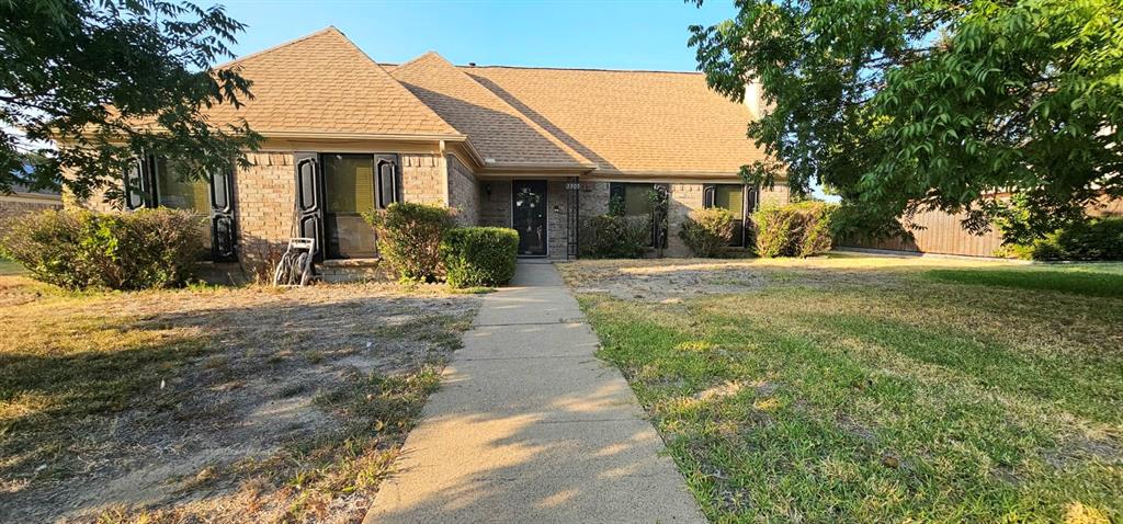 a front view of a house with a yard and potted plants