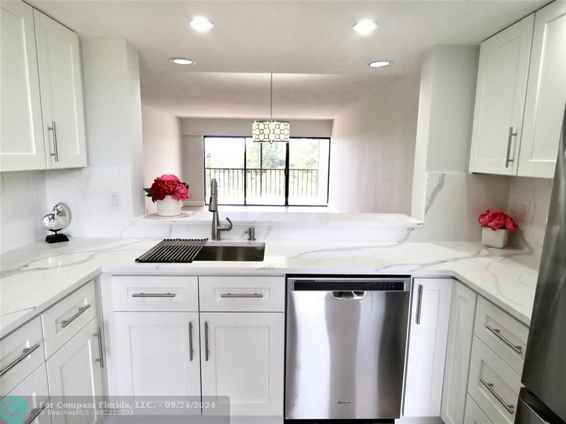 a kitchen with white cabinets sink and white appliances