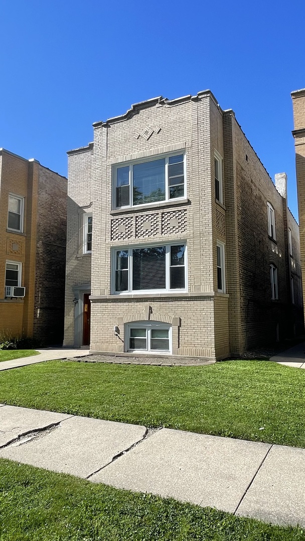 a front view of a building with a yard