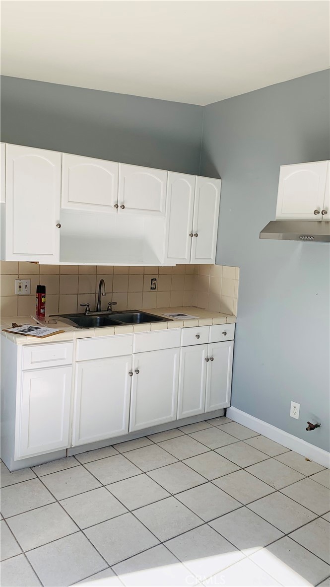 a kitchen with granite countertop white cabinets and white appliances