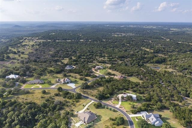 an aerial view of house with yard and mountain view in back