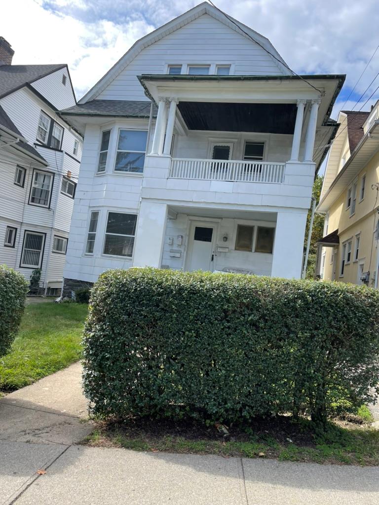 a front view of a residential apartment building with a yard