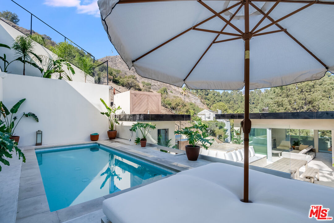 a view of a patio with a table and chairs under an umbrella